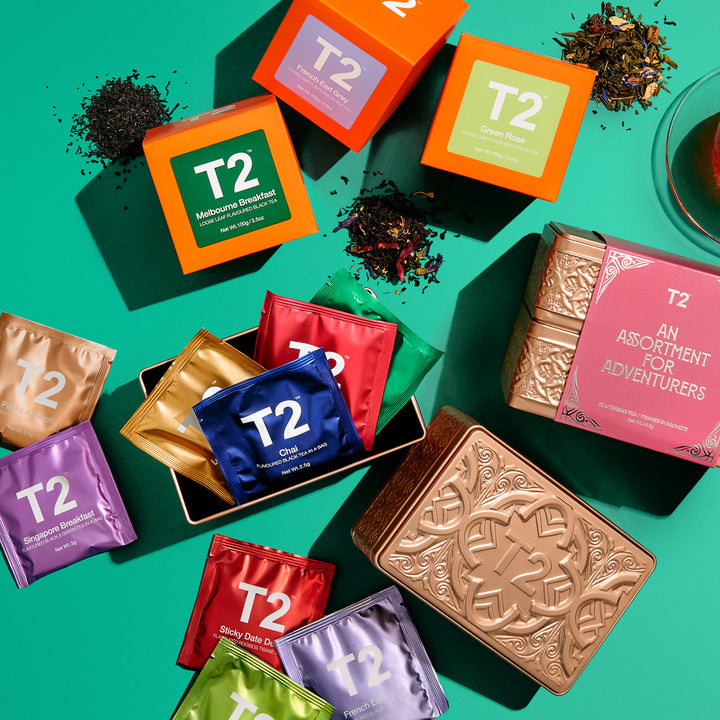Collection of T2 tea packaging on a green background