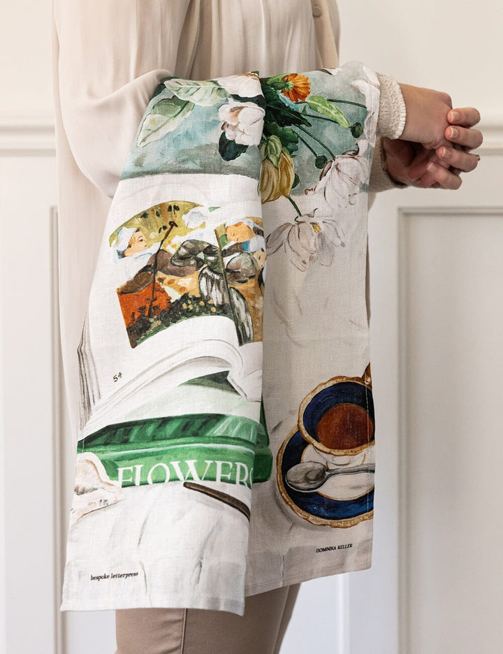 Person holding a floral theme linn tea towel