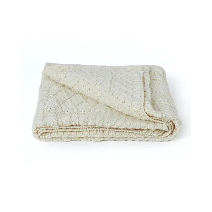 Folded beige quilt on a white background