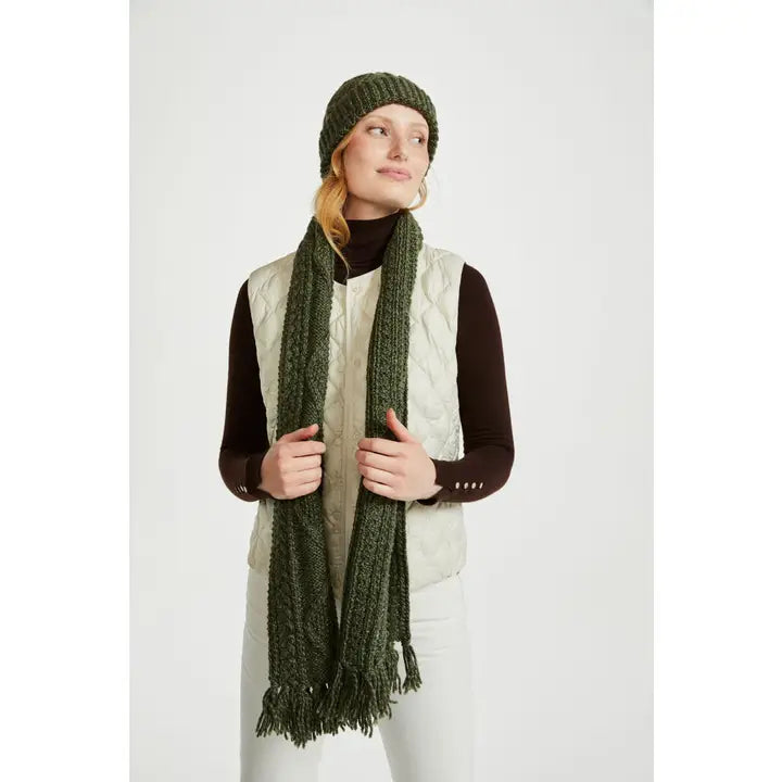 Woman wearing a green knitted hat and scarf on a white background