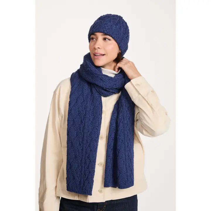 Woman wearing a blue knitted scarf and hat on a white background