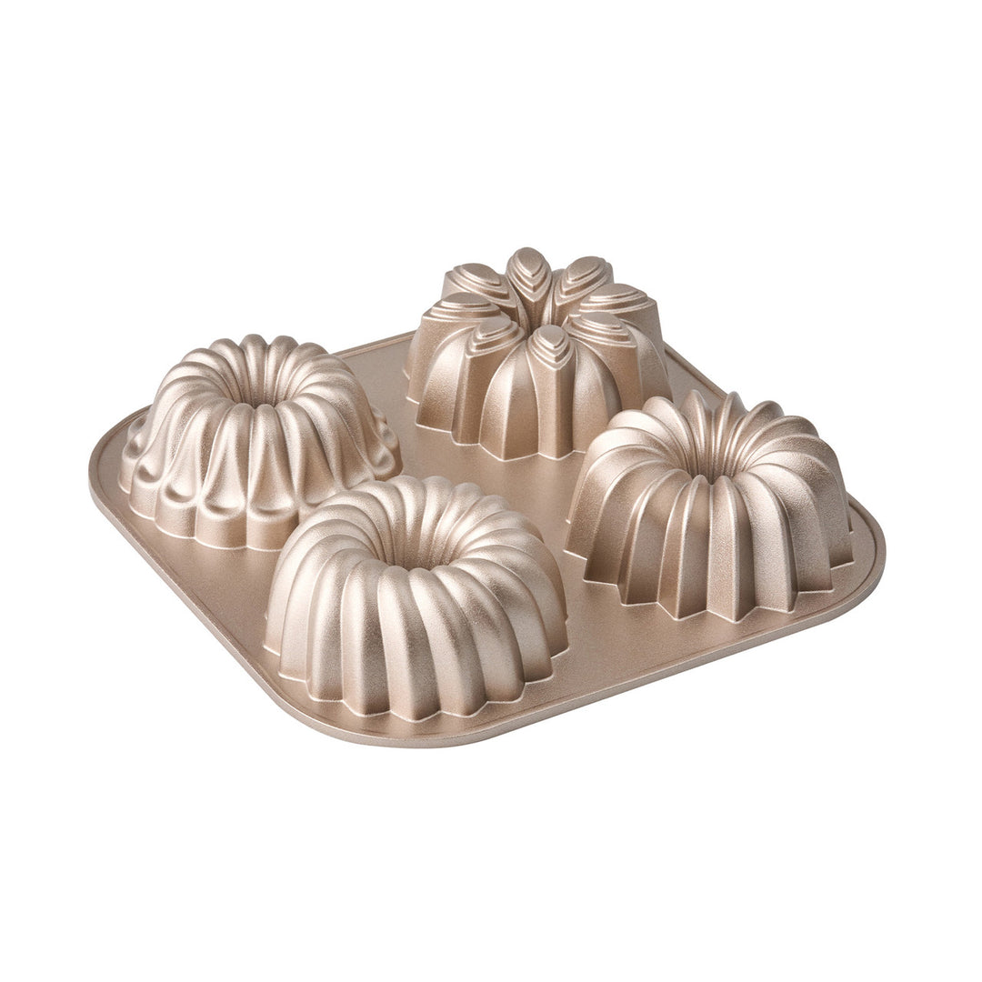 Bundt cake pan with four individual mold sections on a white background