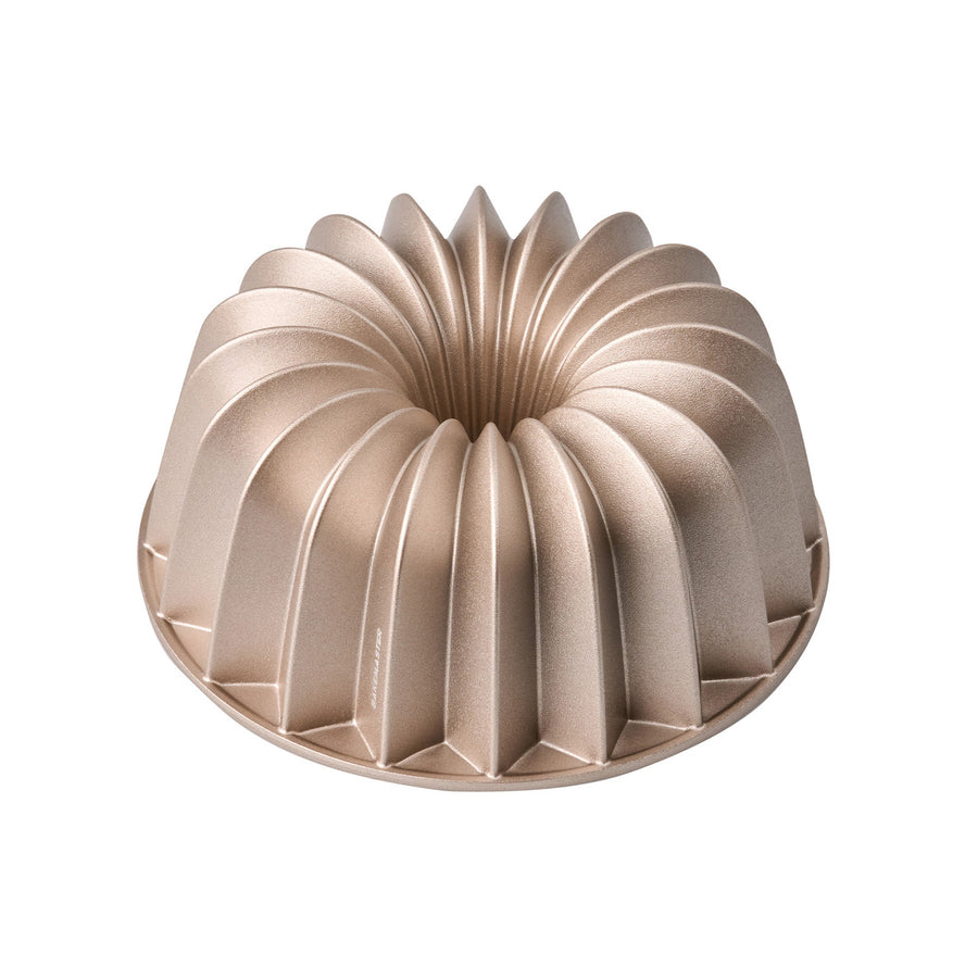 Gold bundt cake mold on a white background