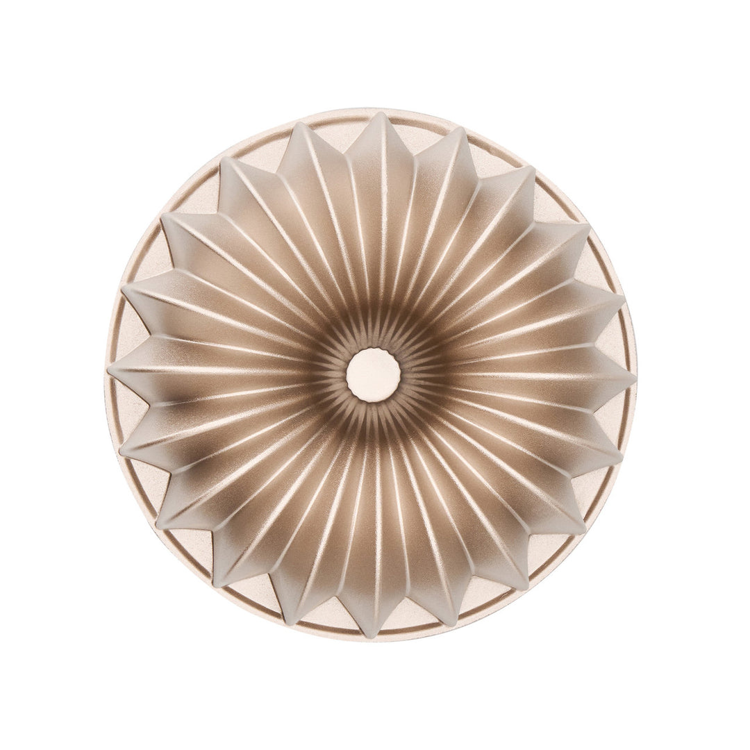 Gold bundt cake mold on a white background