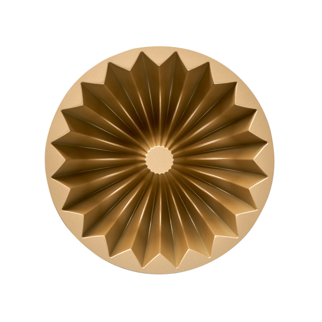 Gold bundt cake mold on a white background