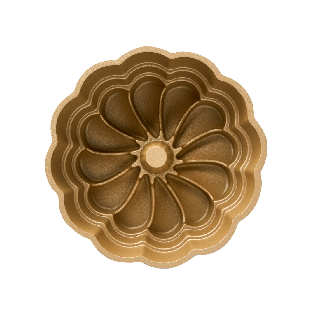 Gold cake pan with decorative pattern on a white background