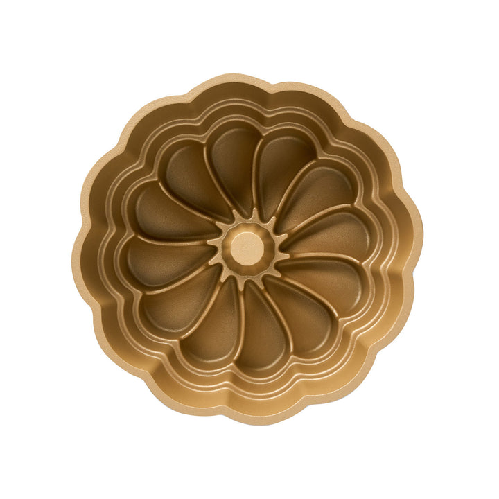 Gold cake pan with decorative pattern on a white background