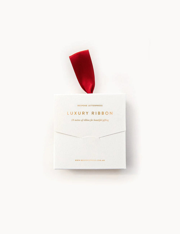 Box of luxury ribbon with a red ribbon on a white background