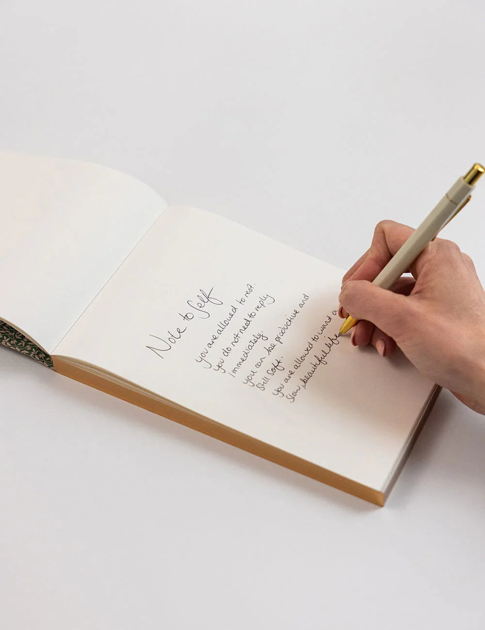 Hand writing in a notebook with a pen on a white background