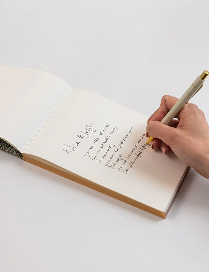 Hand writing in a notebook with a pen on a white background