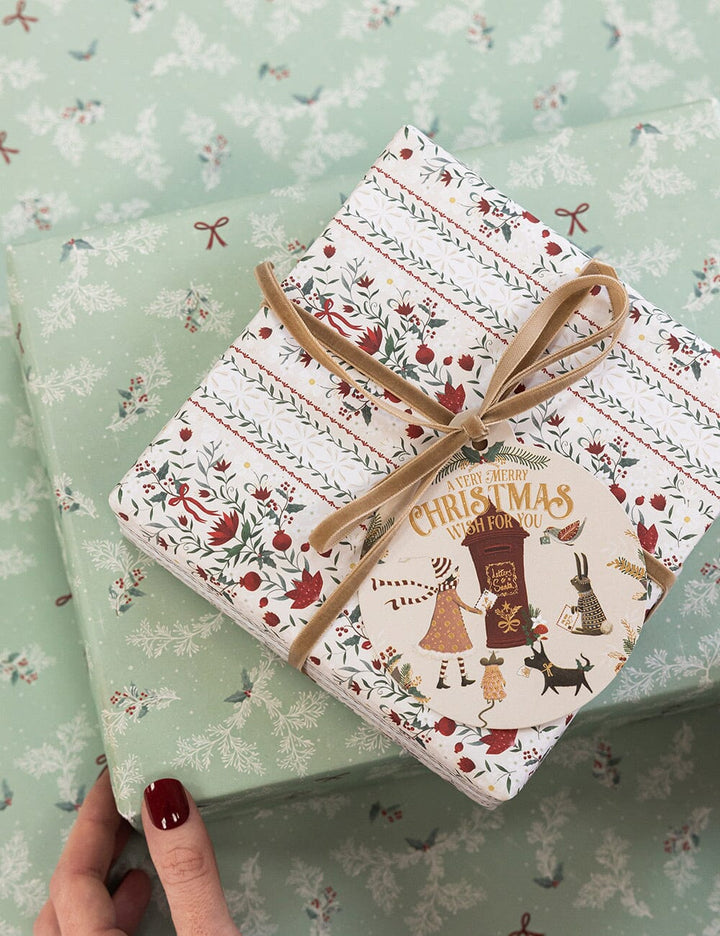 Gift wrapped in festive paper with a decorative ribbon on a matching background