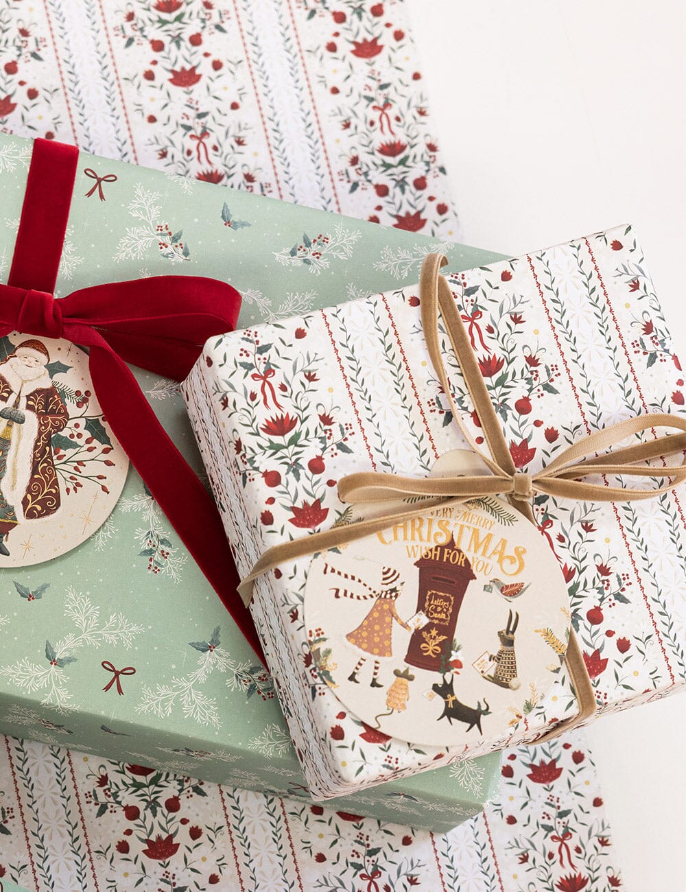 Two Christmas-themed gift boxes with decorative ribbons on a matching patterned background.