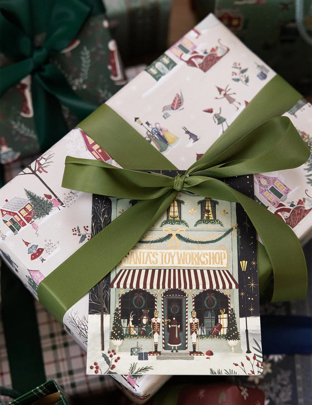 Gift box with festive design and green ribbon on a blurred background