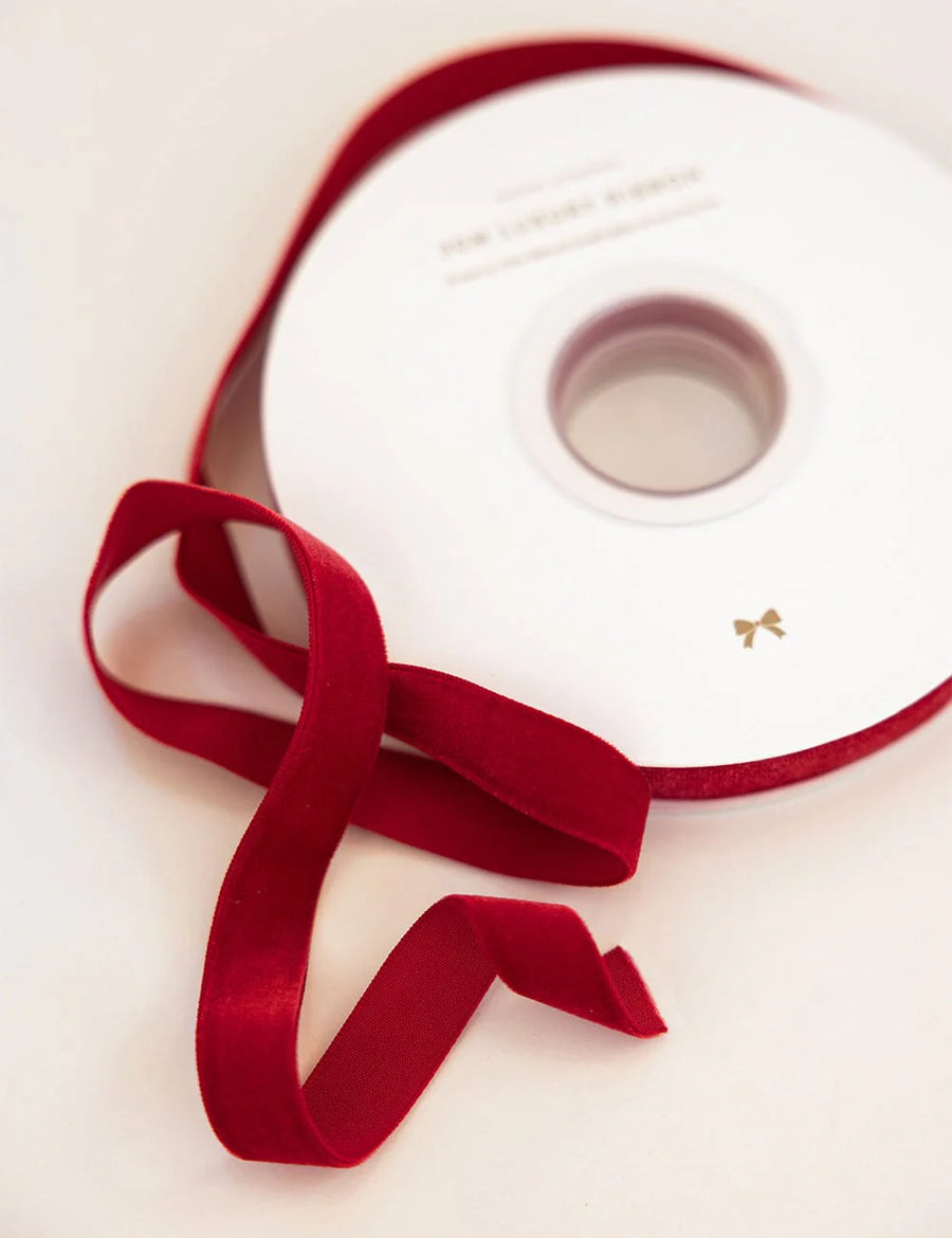 White spool with a red ribbon on a light beige background