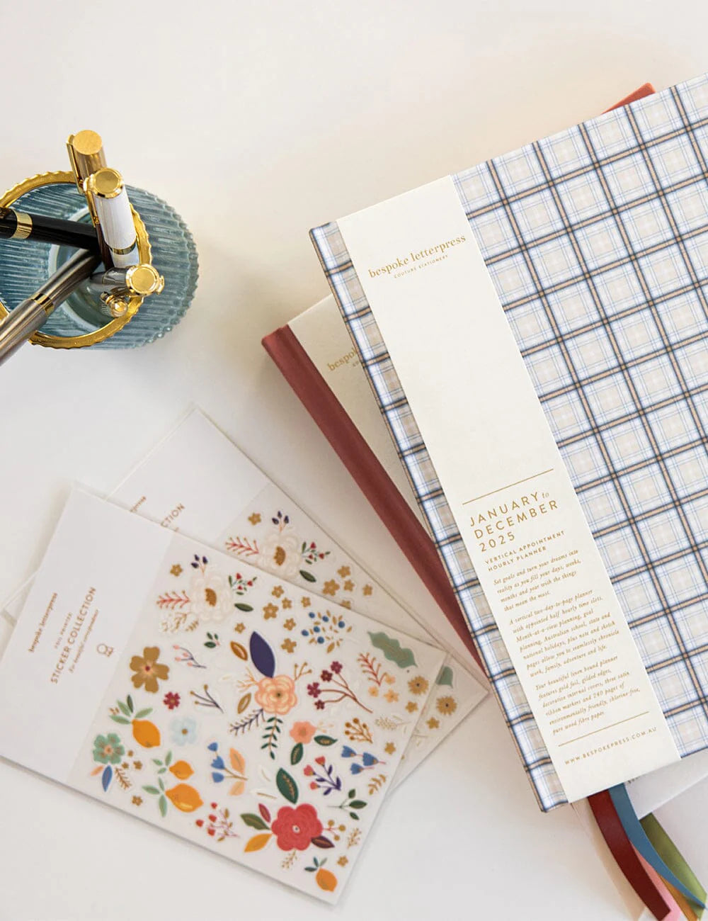 Collection of planners and notebooks with different designs on a light surface.