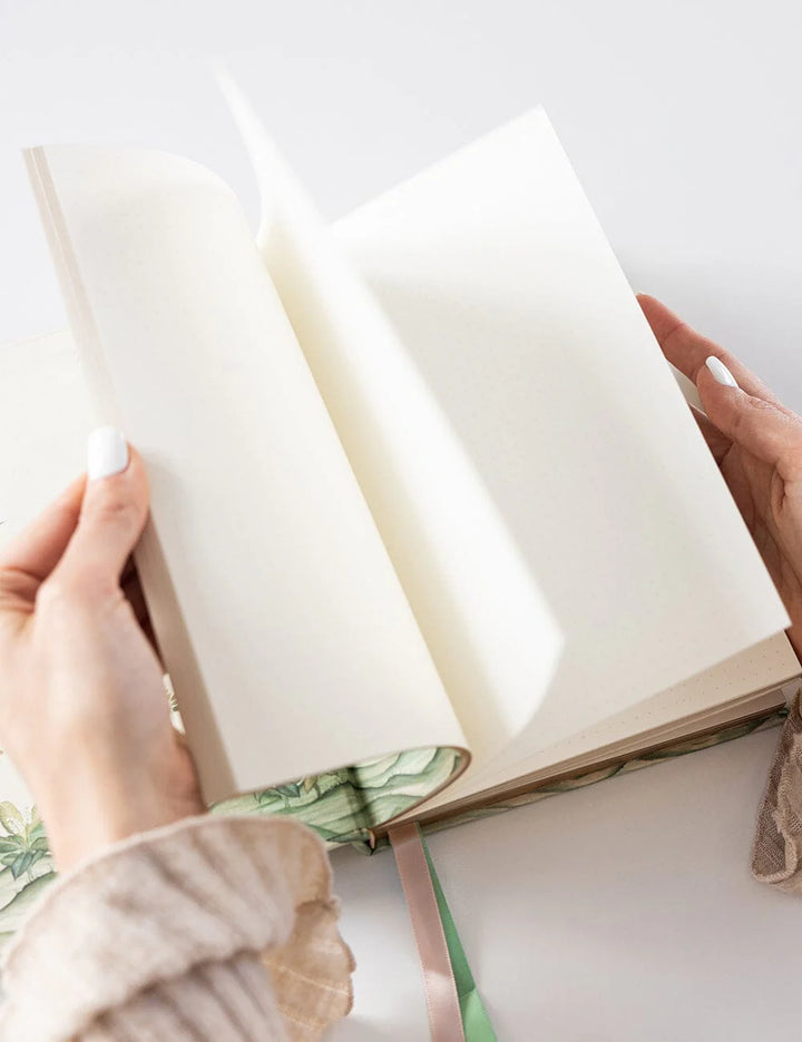 Open book held by hands on a light background