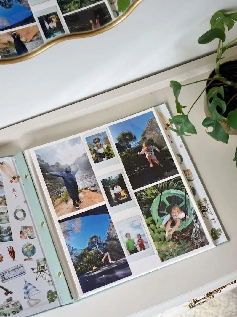 Open photo album with scenic and nature-themed images on a white surface.