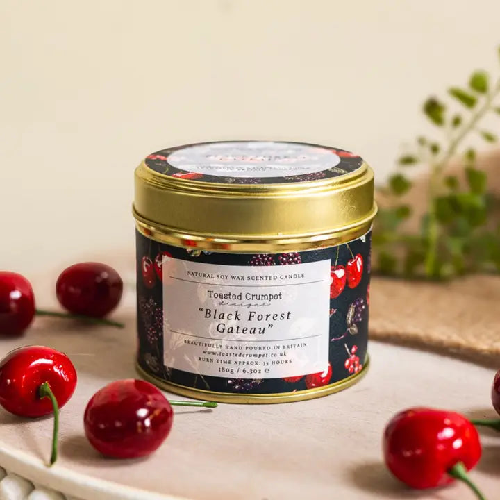 Scented candle in a tin with cherry design on a neutral background