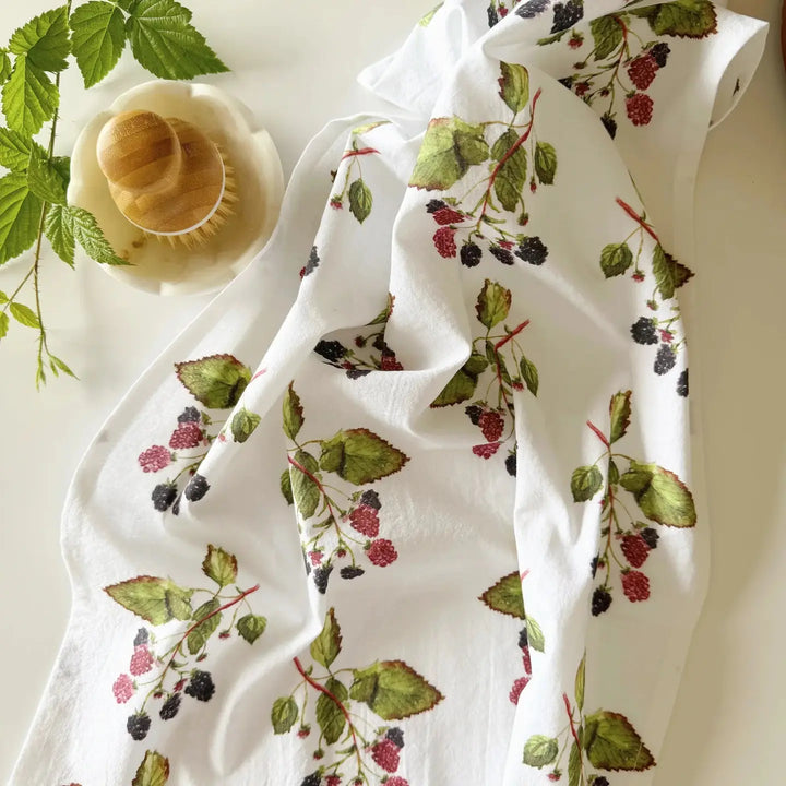 White fabric with green leaf and berry pattern on a white background
