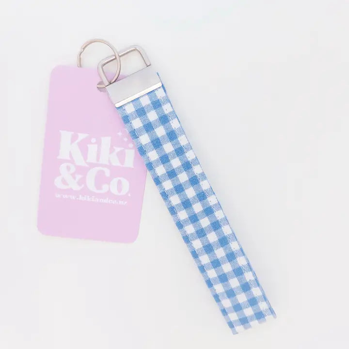 Keychain with pink pouch and blue checkered strap on a white background
