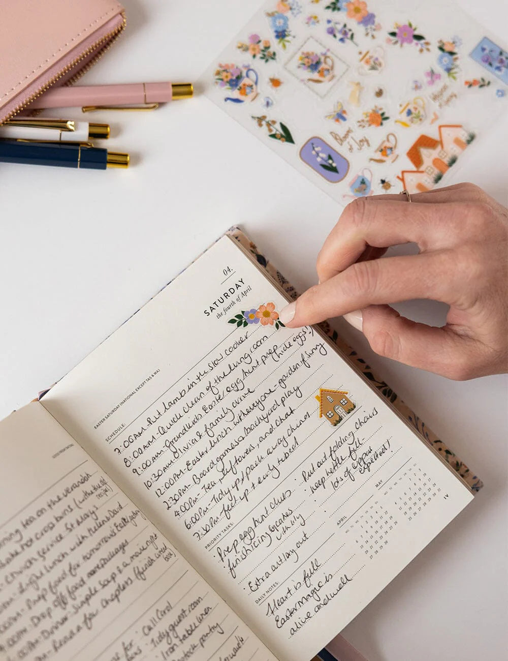 Handwritten notes in a notebook with decorative elements on a white surface