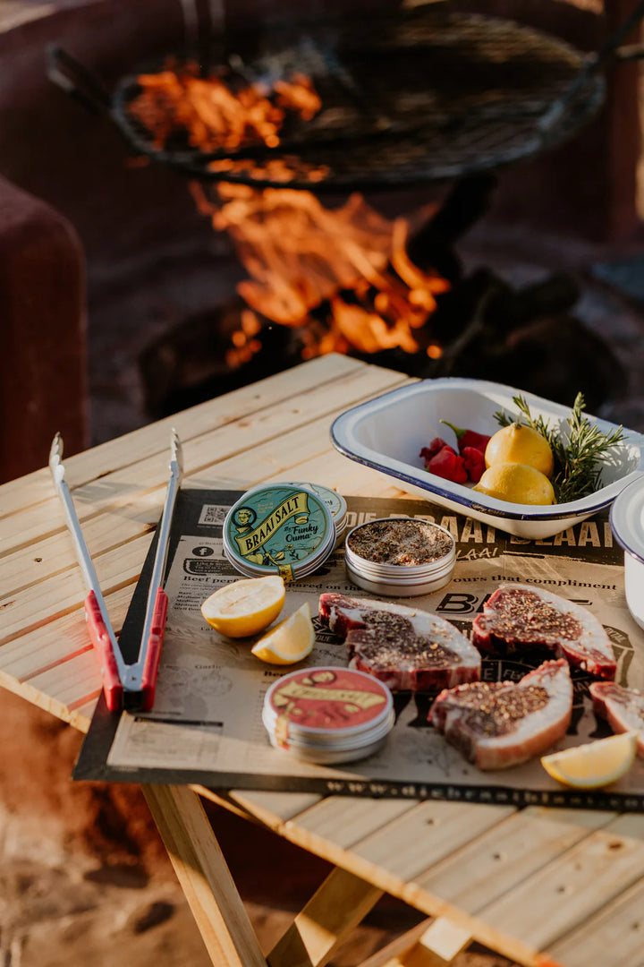 Wooden table with food and drinks by a fire pit