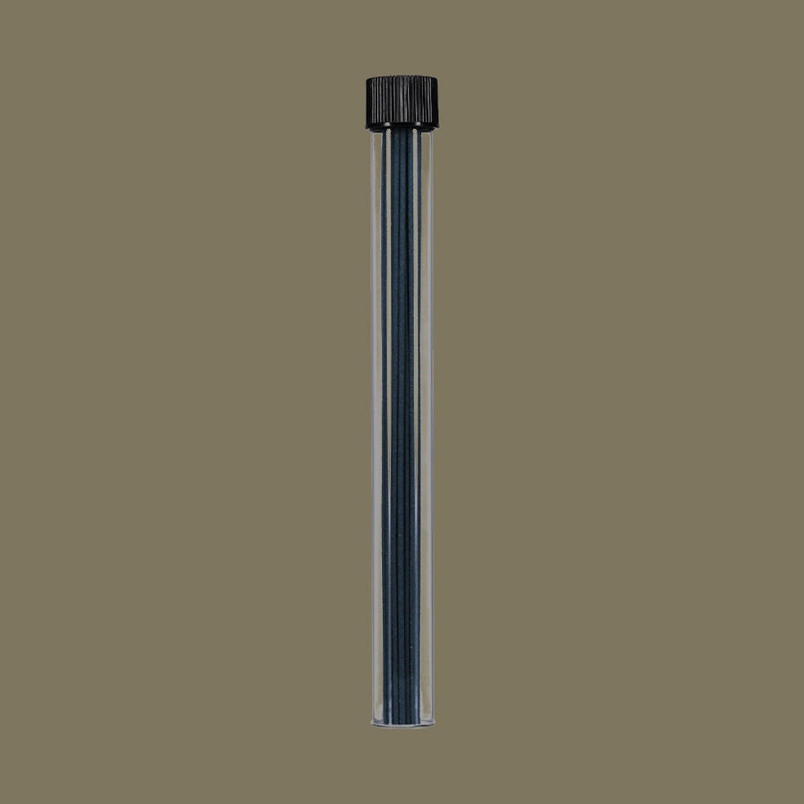 Clear plastic tube with incense sticks inside on a brown background