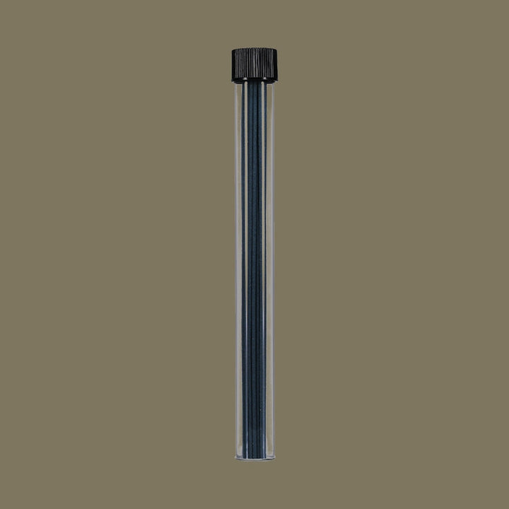 Clear plastic tube with incense sticks inside on a brown background