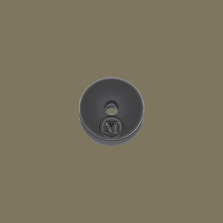 Dark gray incense holder with a central logo on a matching background