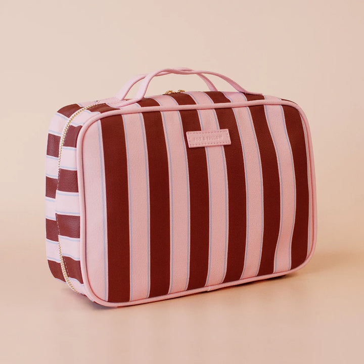 Striped toiletry bag with a visible brand logo on a beige background