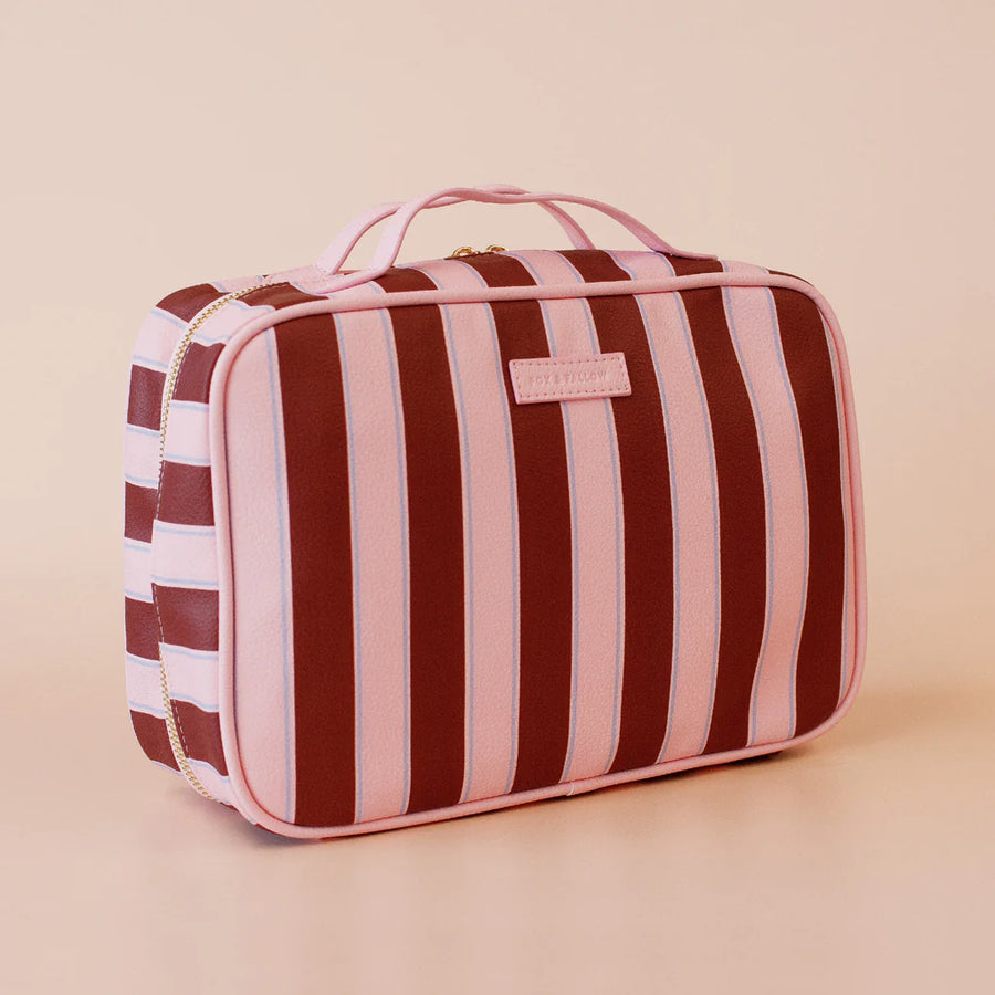 Striped toiletry bag with a visible brand logo on a beige background