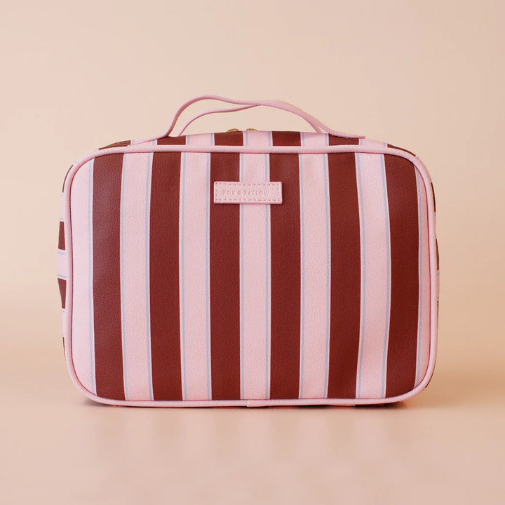 Striped toiletry bag with a visible brand label on a beige background