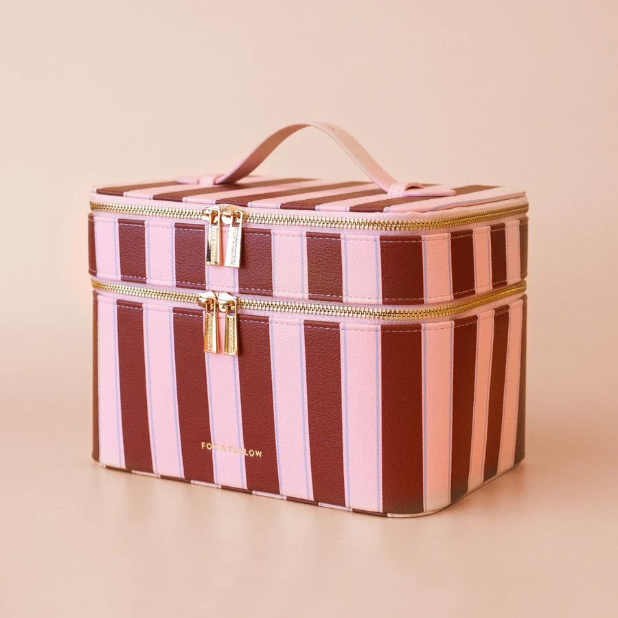 Striped makeup bag with gold zipper on a beige background