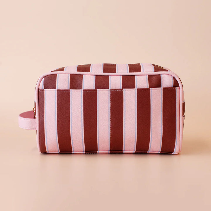 Striped toiletry bag with pink and brown pattern on a beige background