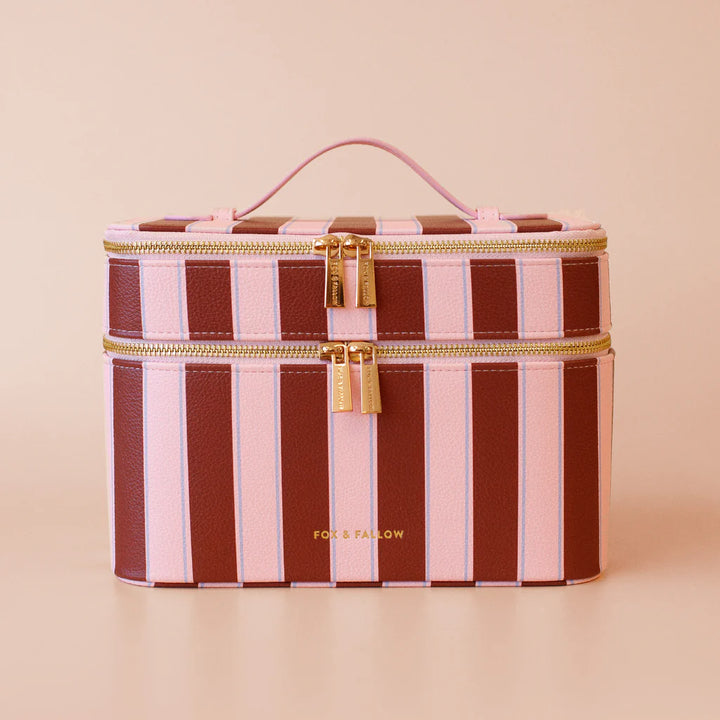 Striped makeup bag with gold zipper and 'FOX & FALLOW' branding on a beige background