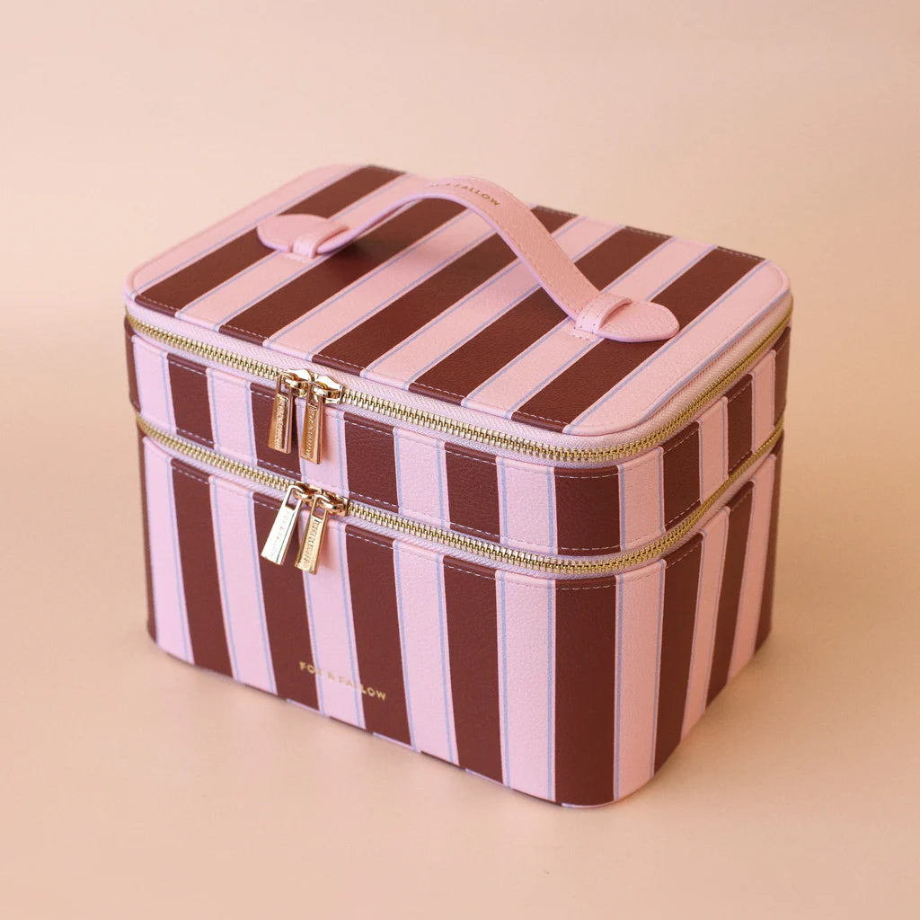 Striped makeup bag with gold zipper on a beige background