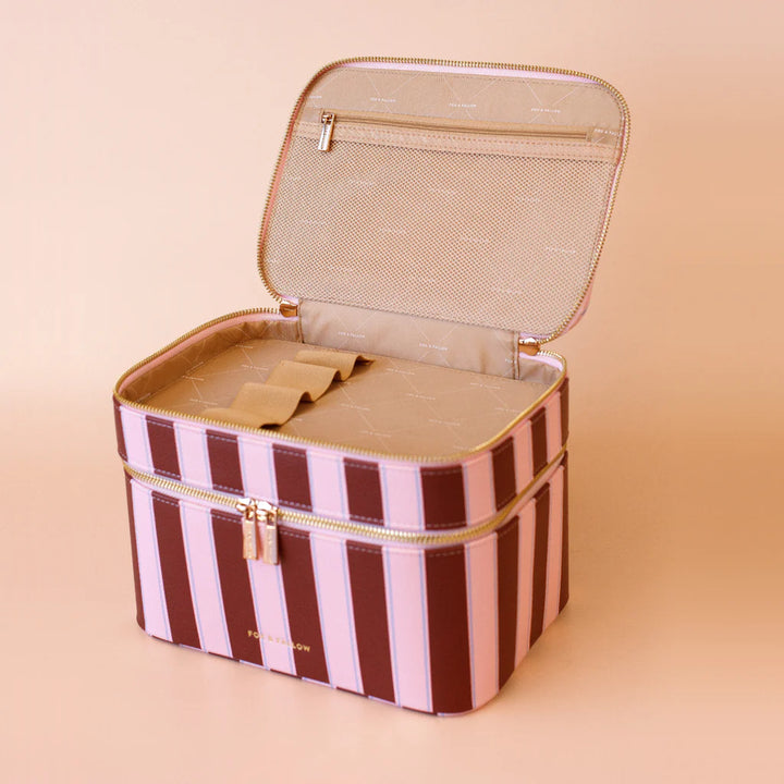 Striped makeup bag with gold zipper on a beige background