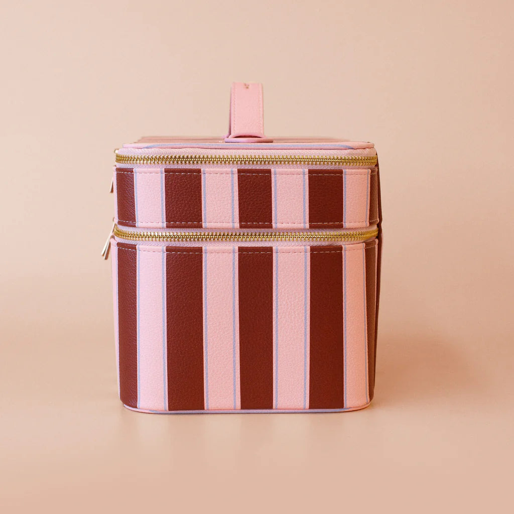 Striped cylindrical cooler bag with gold zipper on a beige background