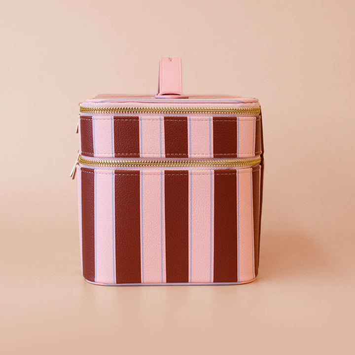 Striped cylindrical cooler bag with gold zipper on a beige background