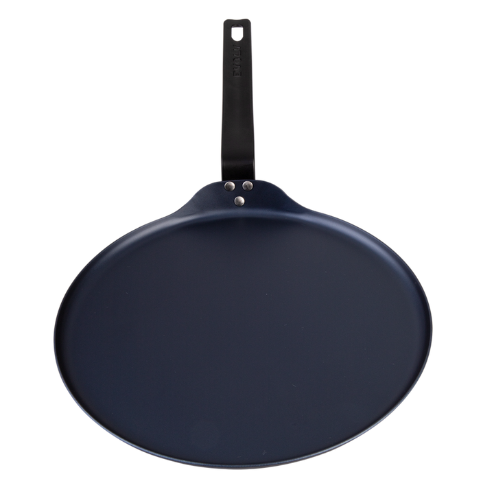 Black carbon steel pancake pan with a handle on a white background