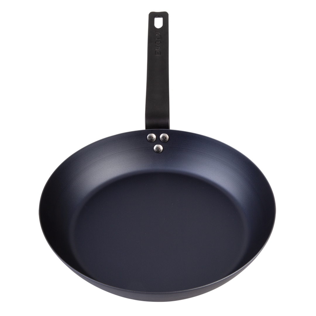 Black carbon steel frying pan with a handle on a white background