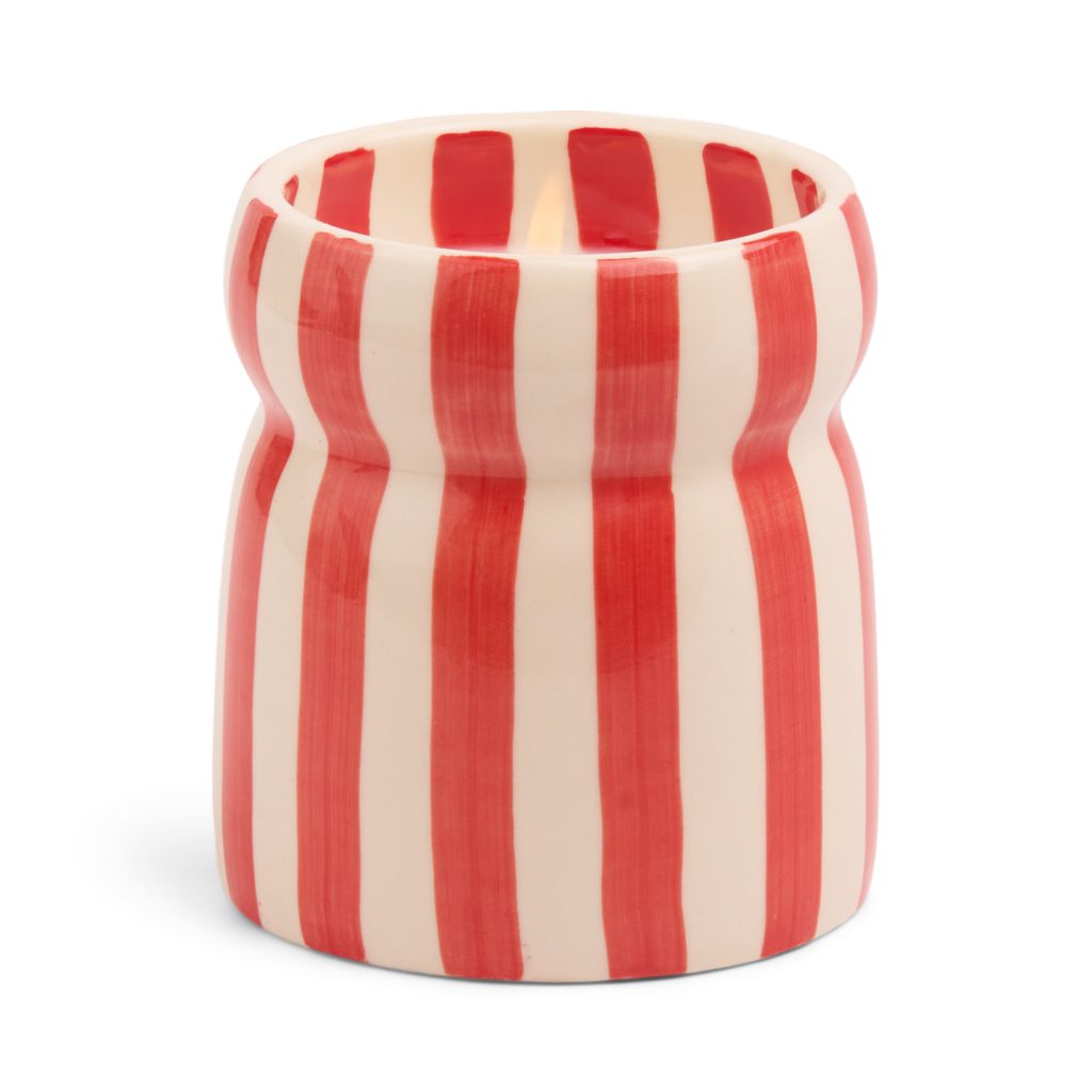 Cylindrical container with candle in it with red and white vertical stripes on a white background