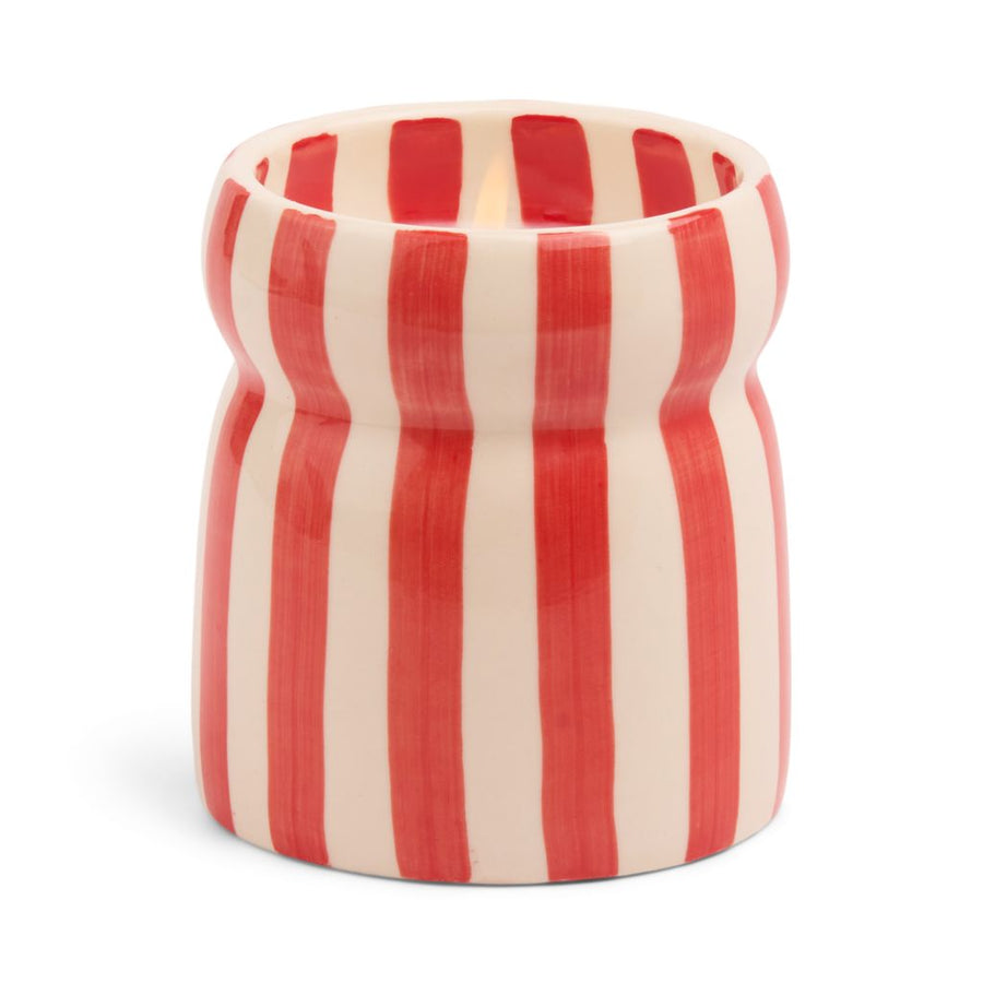 Cylindrical container with candle in it with red and white vertical stripes on a white background