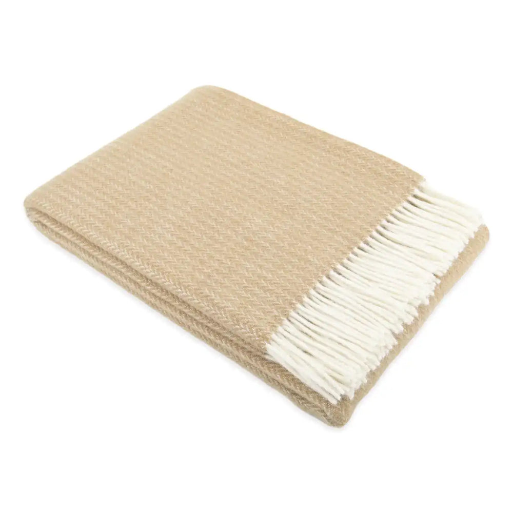 Beige throw blanket with white fringe on a white background