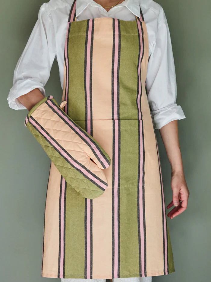 Person wearing a striped apron and oven mitt on a plain background
