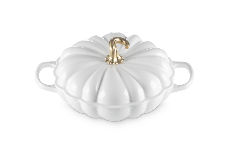 A white pumpkin-shaped lidded casserole dish with side handles and a metallic gold stem on a clean white background.
