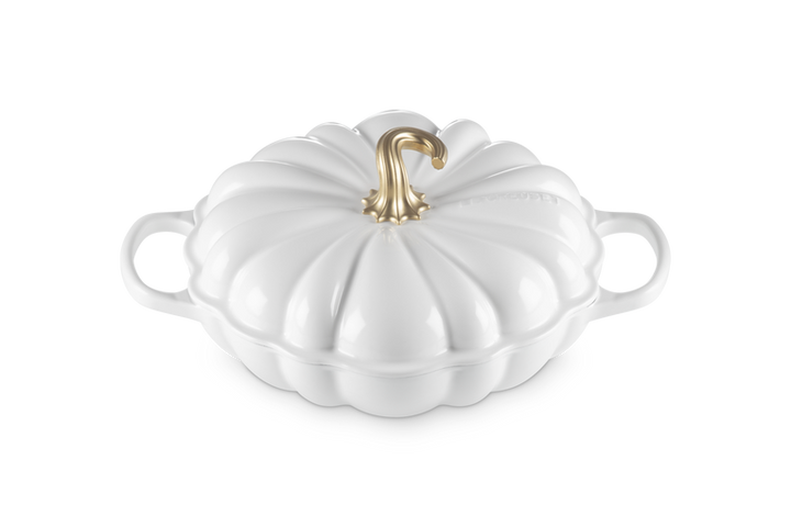 A white pumpkin-shaped lidded casserole dish with side handles and a metallic gold stem on a clean white background.