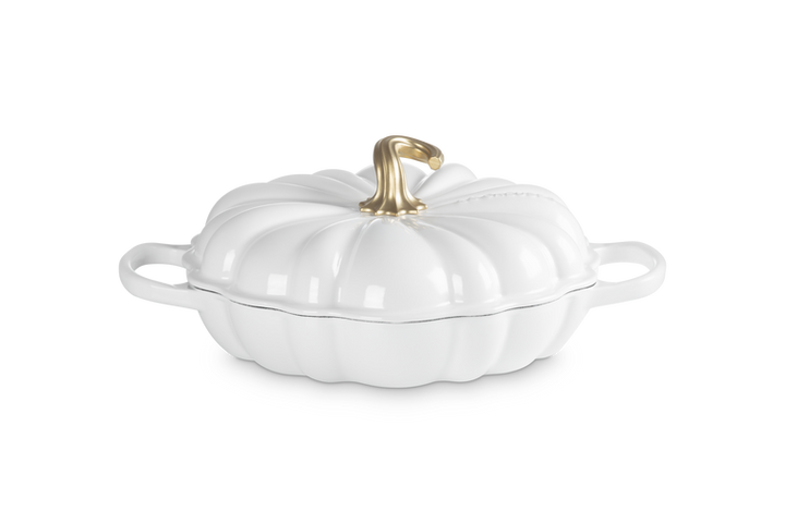 A white pumpkin-shaped lidded casserole dish with side handles and a metallic gold stem on a clean white background.