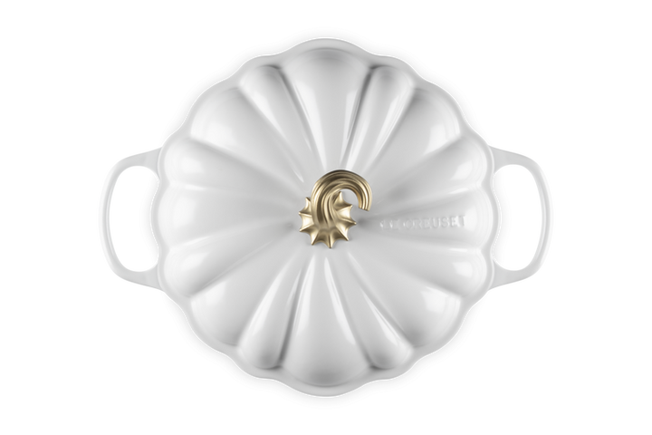 A white enameled cast iron Dutch oven lid with a ribbed pumpkin-inspired design and a gold-tone metal knob, shown from a top-down view on a white background.