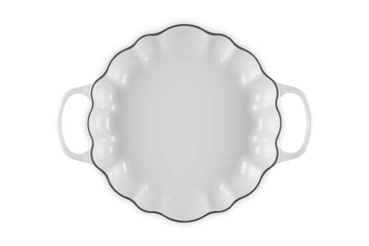 A white baking dish with a scalloped rim and two side handles, shown from a top-down view on a white background.